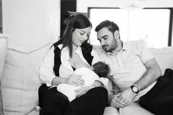 Parents allaitant leur bébé, tendrement. Portfolio Grossesse - Gabriel, à la maison.