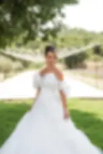 Belle mariée en robe blanche, regardant vers le bas, dans un cadre verdoyant, nature