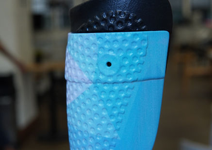 Rear close-up of a bright blue AFO with a black TPU insert visible along the upper edge.