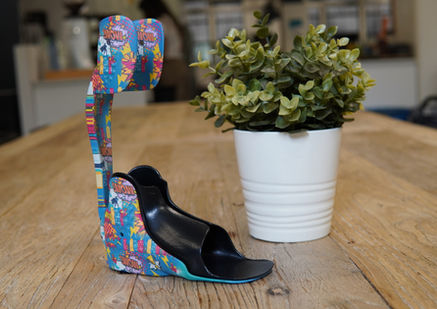 Colourful patterned AFO fitted with a black TPU insert in a product video thumbnail beside a plant.