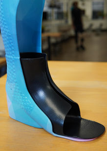 Black TPU insert fitted inside a bright blue custom AFO, shown from the side.
