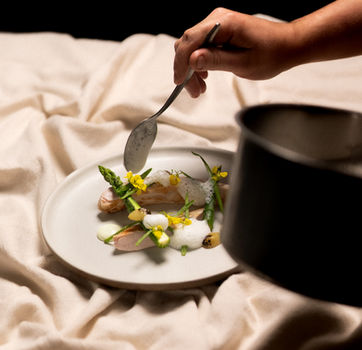 Hand garnerend gerecht met asperges en schuim