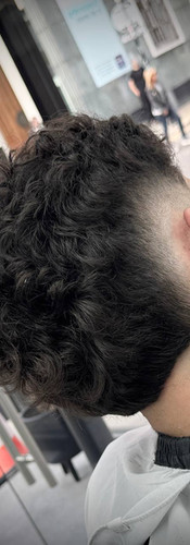 Curly mullet fade haircut with sharp sides at Creato Barber & Bar Liverpool
