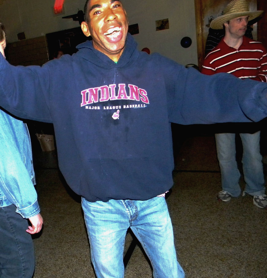 Excited man in blue hoodie with arms outstretched.
