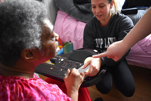 Music therapy intern with two clients viewing cards