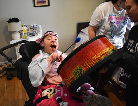 Person playing drum in music therapy session