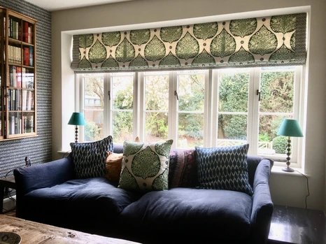Roman blinds with a green pattern on them.
