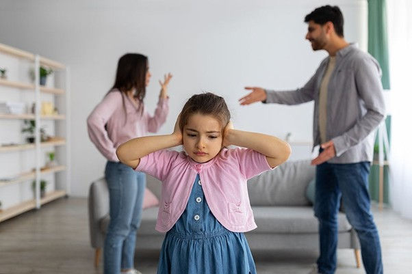 Parents arguing in background, child upset