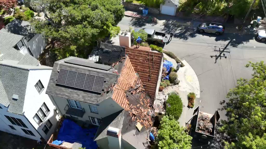 Aerial views of roofing work around roof planes and solar panels
