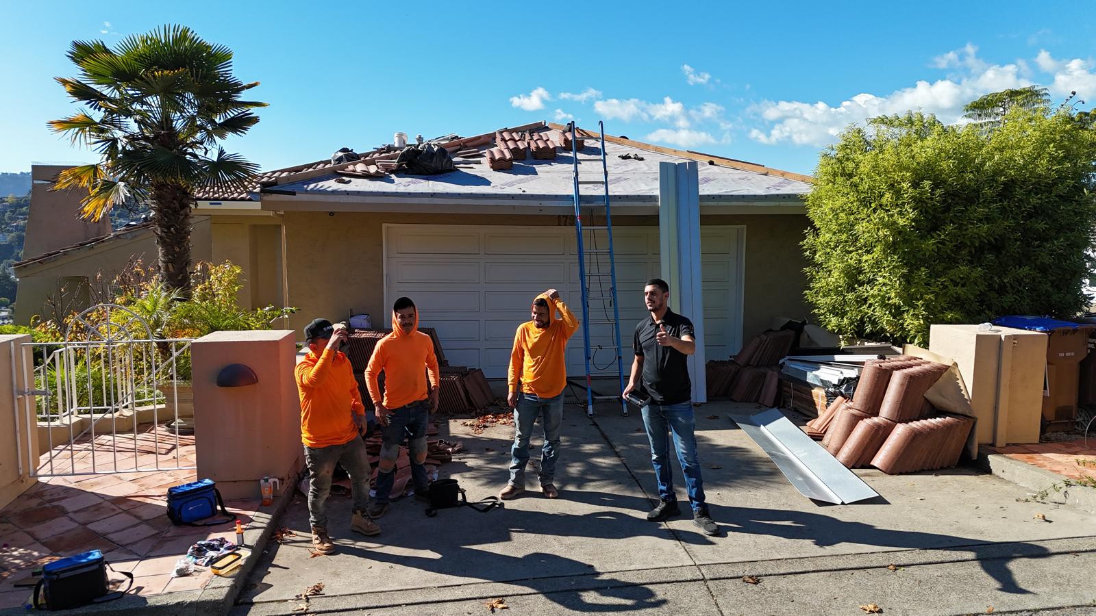 The roofing crew outside a home during tile-roof work.