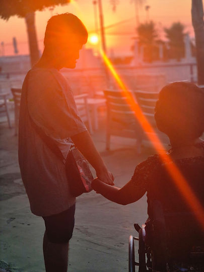 Due persone che si tengono per mano al tramonto