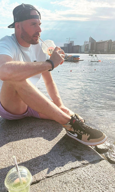 The founder of Freezo's Feast sitting in Copenhagen next to the water