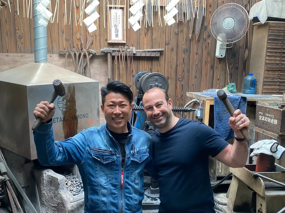 Guest holding the finished knives at the workshop