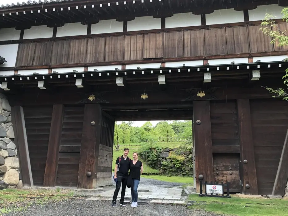 Tour guests posing under the Koriyama Castle wooden gate
