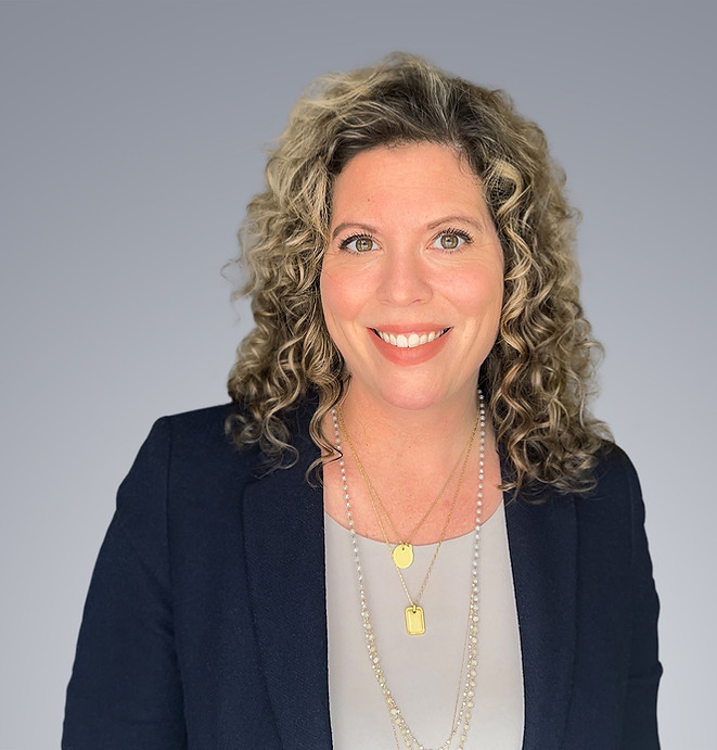 Headshot of Lisa Temple from the shoulders up smiling in a business suit with necklaces.