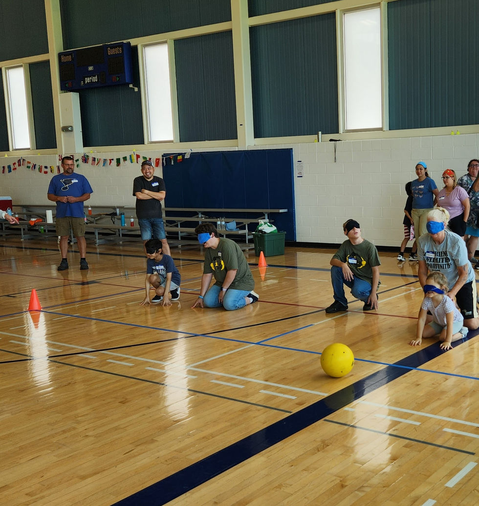 People playing kickball on a basketball court, an active game with a ball.