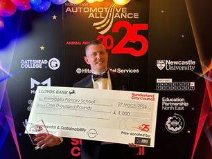 Peter Williams holding a cheque for £1000 for Portobello Primary School