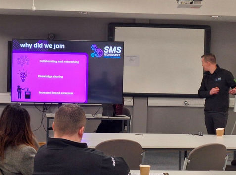 peter williams of sms technology in front of class explaining information on a tv screen