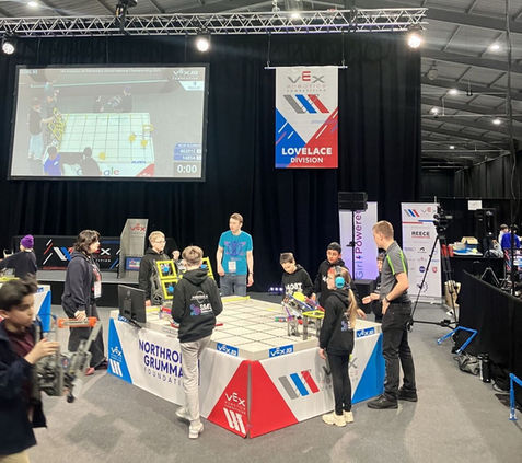 photo of children and teachers at a display stand in an exhibition