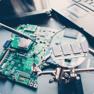 circuit board being assembled under a magnifying glass