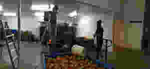 A bin of apples in front of a voran apple mill and press.
