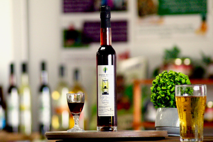 Bottle of coffee liqueur on a table with small glass next to it