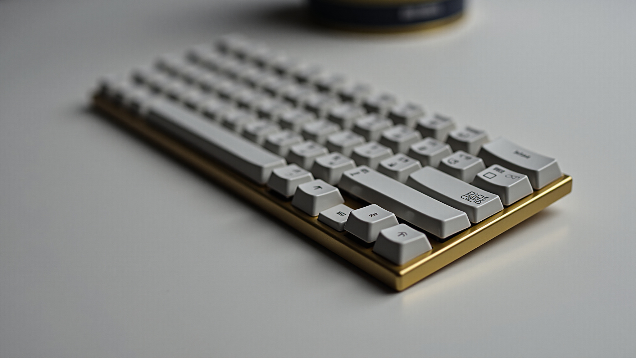 Close-up of a compact white and gold keyboard on a white surface.