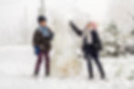 two kids building a snowman