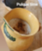 Traditional Mexican clay jar filled with pulque, a fermented agave drink with deep roots in Mesoamerican history and culture.