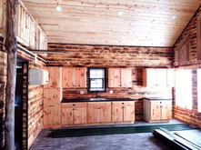 Wood kitchen cabinets with a sink below the window in the Salmon Run Cabin.
