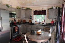 Cabin kitchen with gray cabinets and red accents.