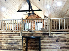 A view of the wall and loft on the second floor opening into the cathedral ceiling accented with wooden beams.