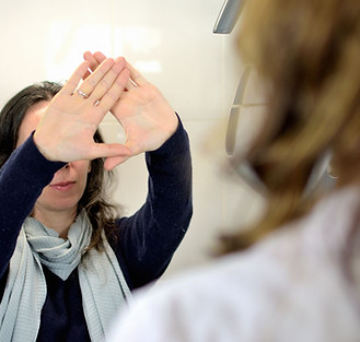 Eine junge Frau macht einen Spätschieltest bei einem Augenarzt.jpg