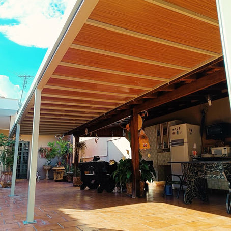 Pergolado metálico com acabamento amadeirado instalado pela Miraflex em área gourmet residencial em Ribeirão Preto