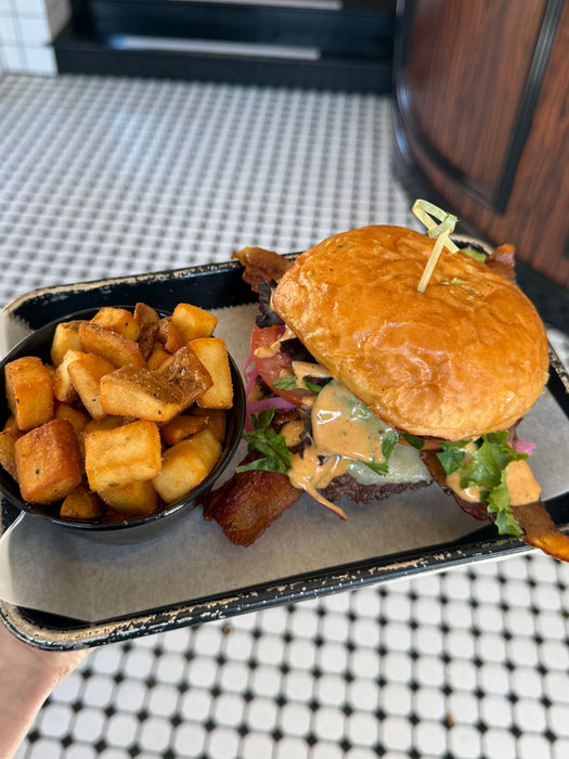 Delicious burger with fries on a tray. Visible text: none. Food photography.
