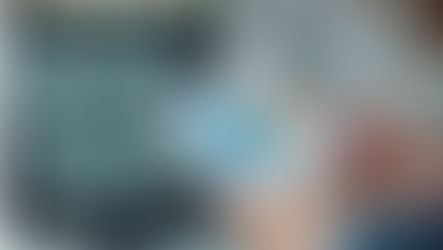 זוג ידיים אוחזות בדף ועליו גרפים צבעוניים. ברקע מסך מחשב ועליו גרפים נוספים. 