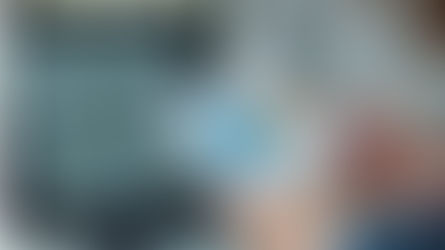 זוג ידיים אוחזות בדף ועליו גרפים צבעוניים. ברקע מסך מחשב ועליו גרפים נוספים. 