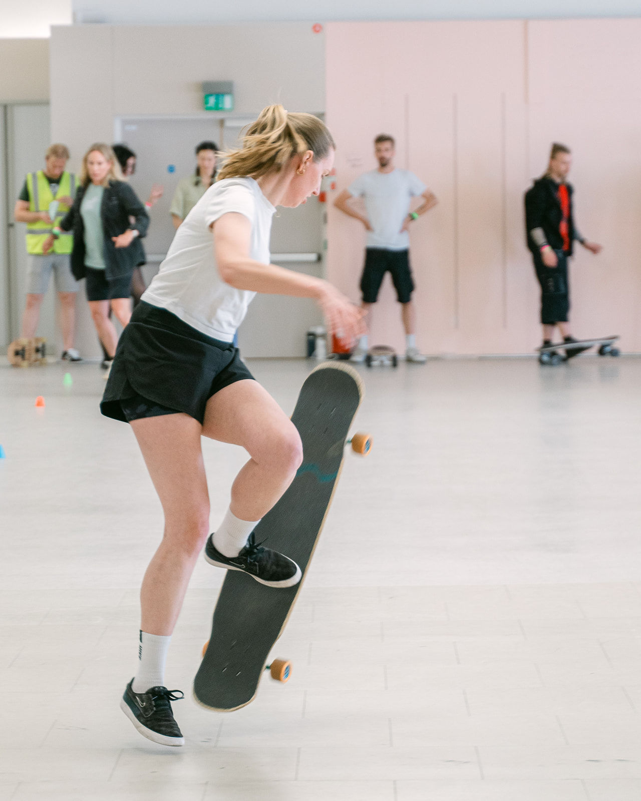 Girl doing longboard freestyle inside 