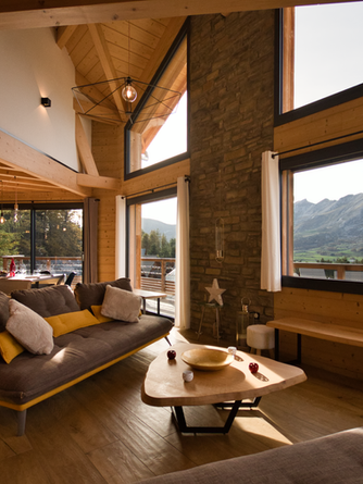 salon-séjour du chalet avec sa salle à manger, et les baies vitrées donnant sur les montagnes