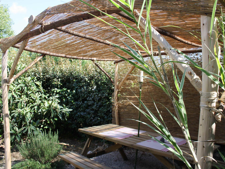 Sous les canisses de la terrasse pergola du Solarium, on se sent comme à la plage, c'est l
