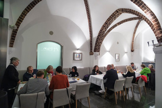 Menschen sitzen an Tischen in einem Gewölberaum, ein Treffen in einem Restaurant.