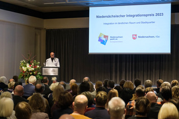 Mann spricht vor Publikum, Niedersächsischer Integrationspreis 2023, Integration, Gebäude