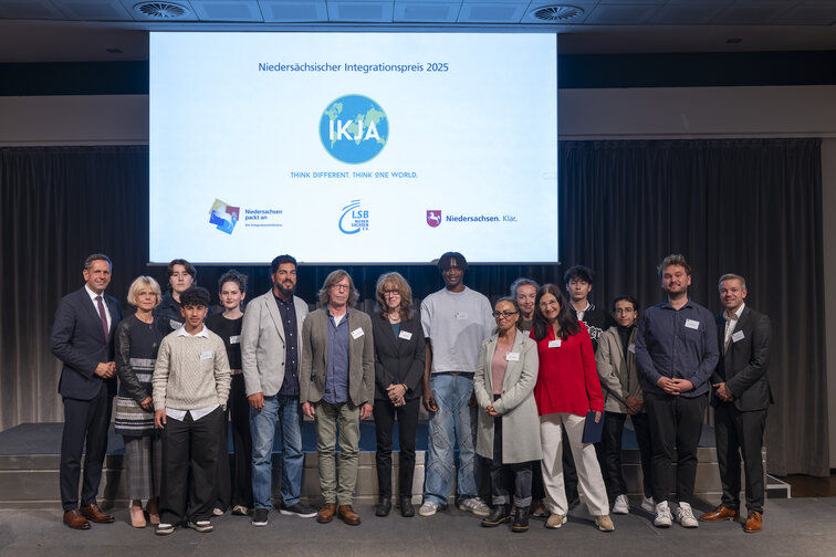Gruppenfoto mit den Preisträger/innen auf der Bühne nach der Verleihung des Integrationspreises.