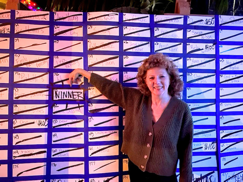 Alyce Hafer pointing to her winning spot on the Cash Bash board