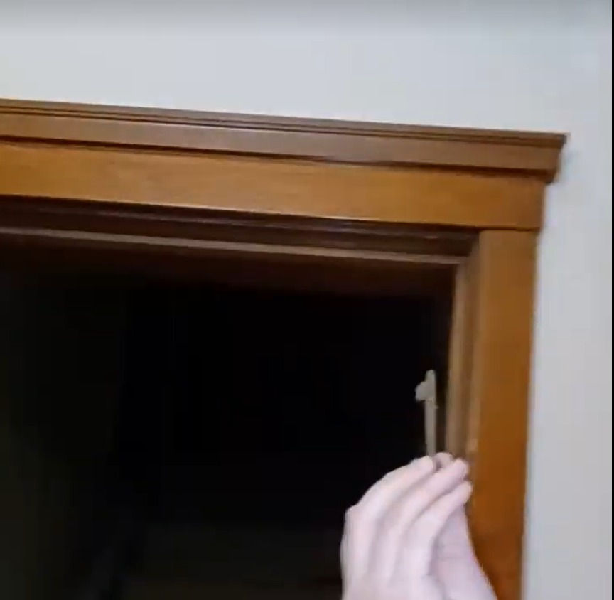 Person holding a key found above the door molding in the Burwell Opera House