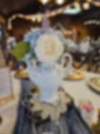 Antique teapot filled with spring flowers and sitting atop a vintage doily surronded by old books and pearls. Timeless Elegance in a photo.