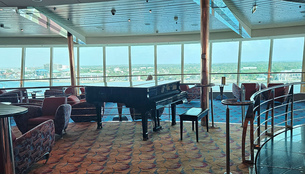The StarQuest Lounge aboard the Royal Carribean Ship Brilliance of the Seas, provides a baby grand piano and panaromic views of the ocean ahead.