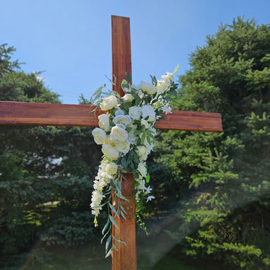 White and ivory florals attached to a wooden cross