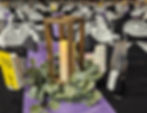 Normal, Illinois fundraising gala wooden lanterns on tables with black tablecloths and lilac table runners. Surrounded by eucalyptus greenery.