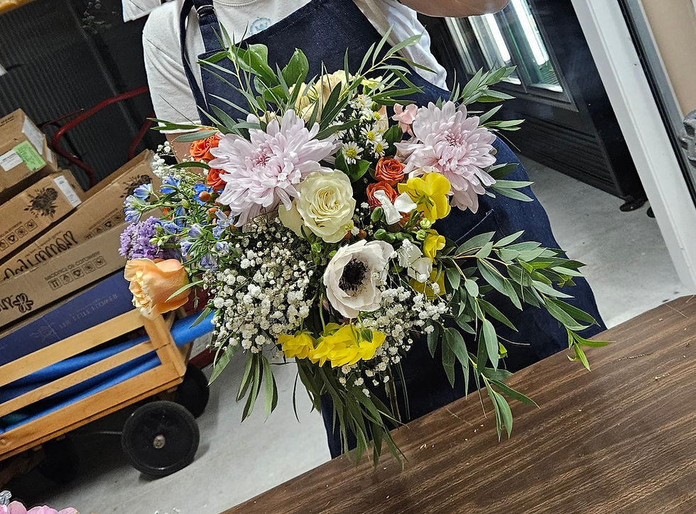Bridal bouquet freshly made by Burlap and Lace featuring fresh eucalyptus greenery, anemone, roses, mum, baby's breathe and pastel colored stock.
